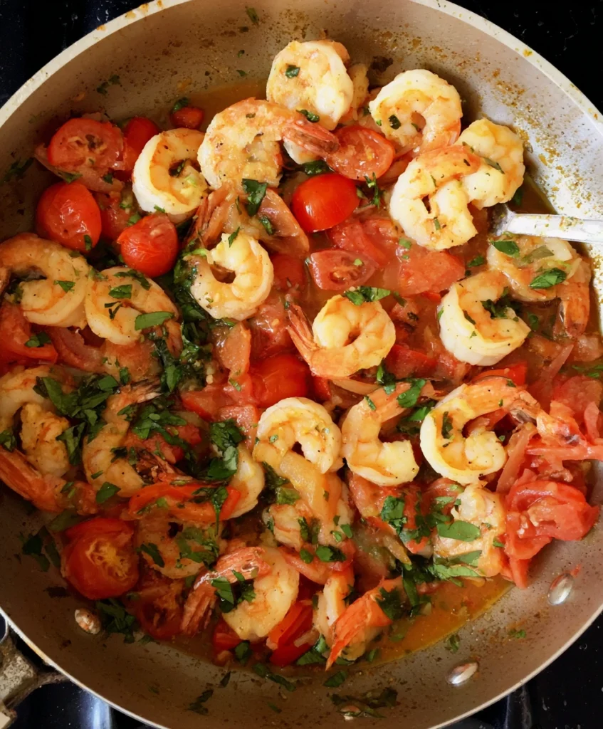 One-Pot Lemon-Garlic Shrimp & Tomatoes: Your 25-Minute Healthy Dinner 2 Cooking shrimp and tomatoes in a skillet for the one-pot lemon-garlic shrimp recipe.